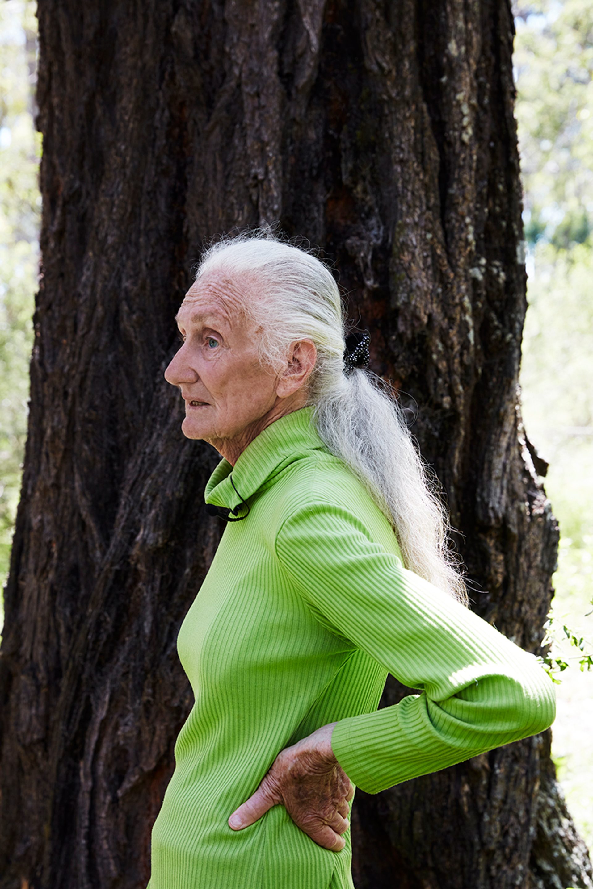 Aunty Fran standing to the left, with a tree behind her and hands on her hips.