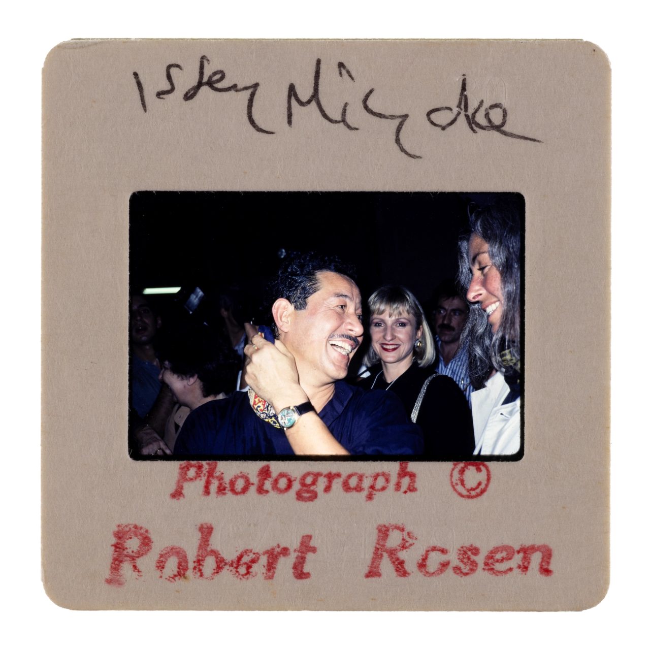 Photo positive slide of 'Issey Miyake, Lagerfeld, Montana', fashion, Runway Shows, photography by Robert Rosen, London and Paris, 1978-2000. A man (Issey Miyake) looking to the right while smiling and laughing, with people beside and behind him.