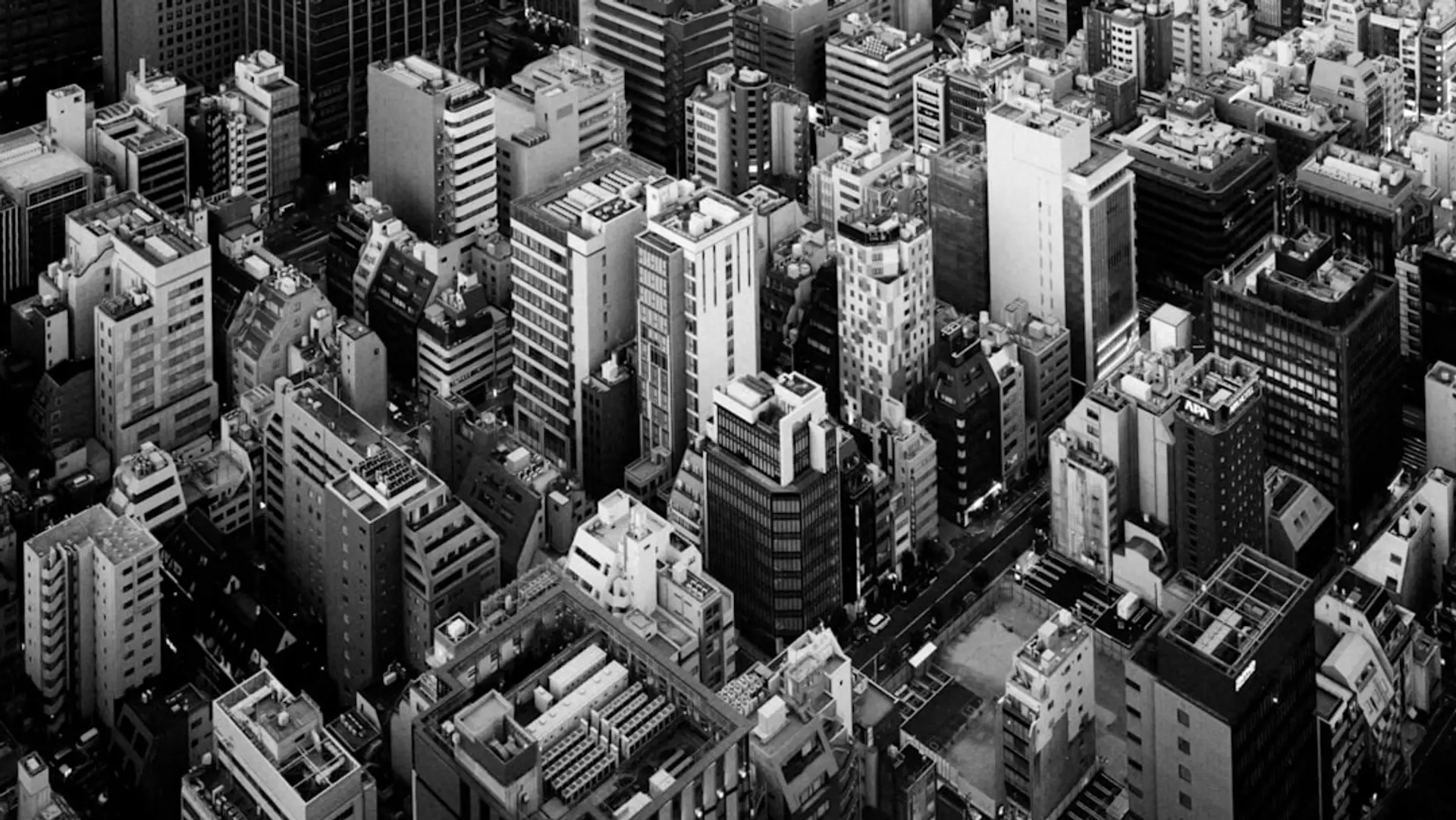 Why Boards Buy the Replacement Narrative — the Political Economy of Procurement - Aerial view of a dense cityscape with many buildings.