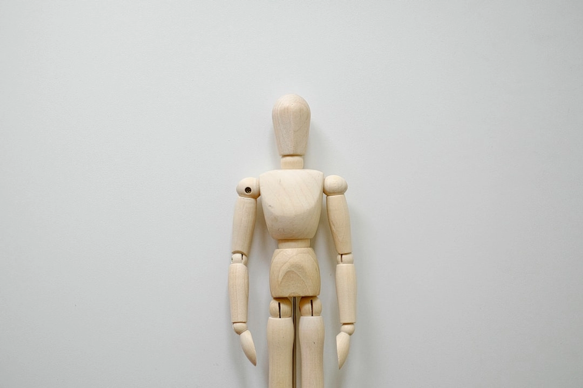 A Practical Blueprint — Design for Augmentation, Not Replacement - a wooden mannequin standing in front of a white wall