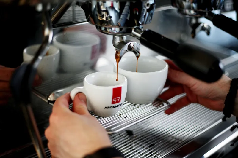 Espresso läuft aus Siebträger in zwei Tassen