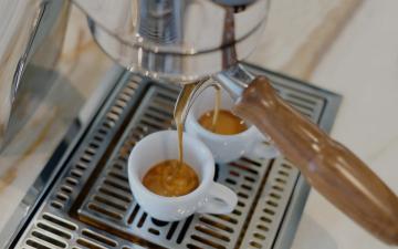 Espresso läuft aus Siebträger in zwei Espressotassen