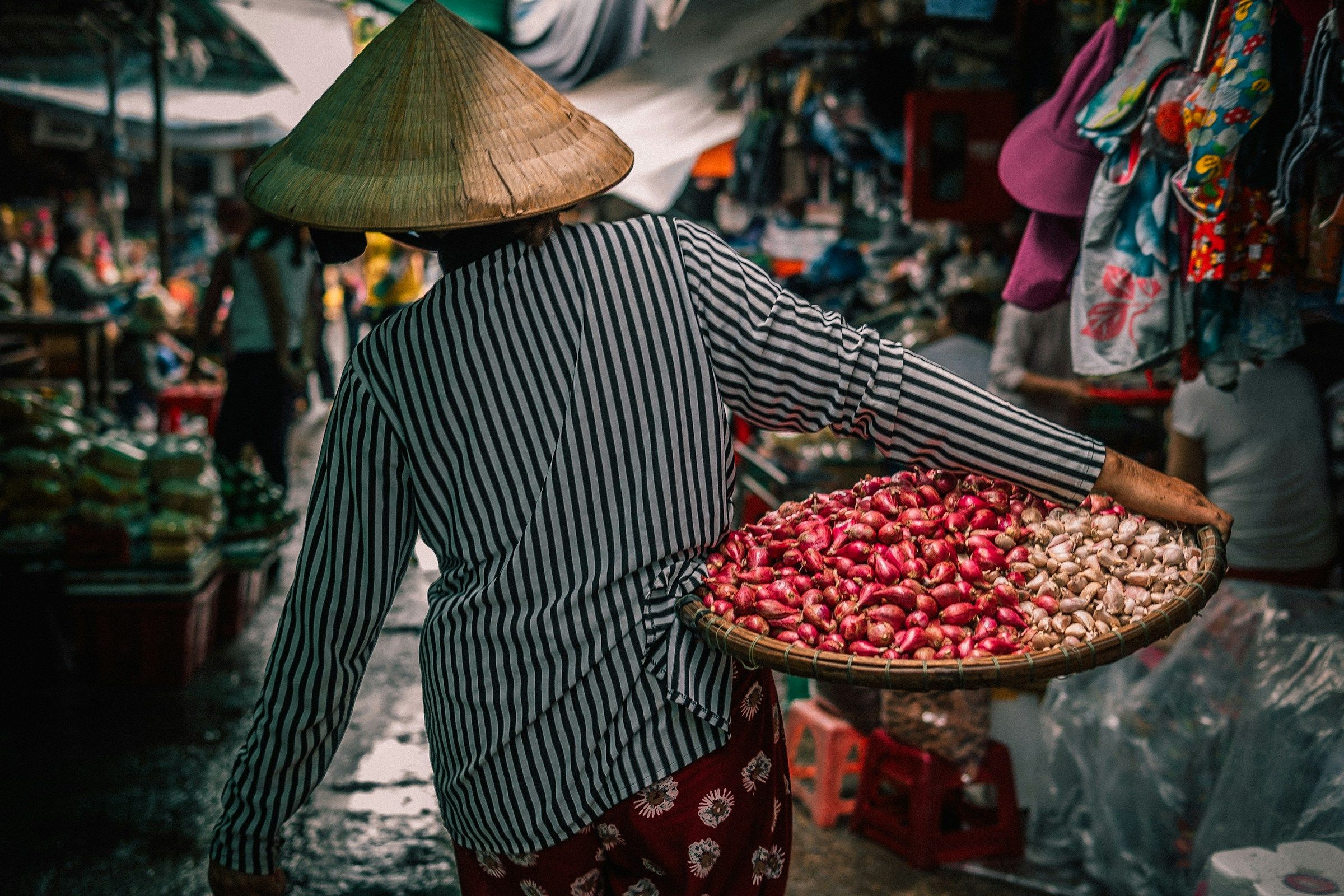 Người phụ nữ gánh rổ rau ở chợ