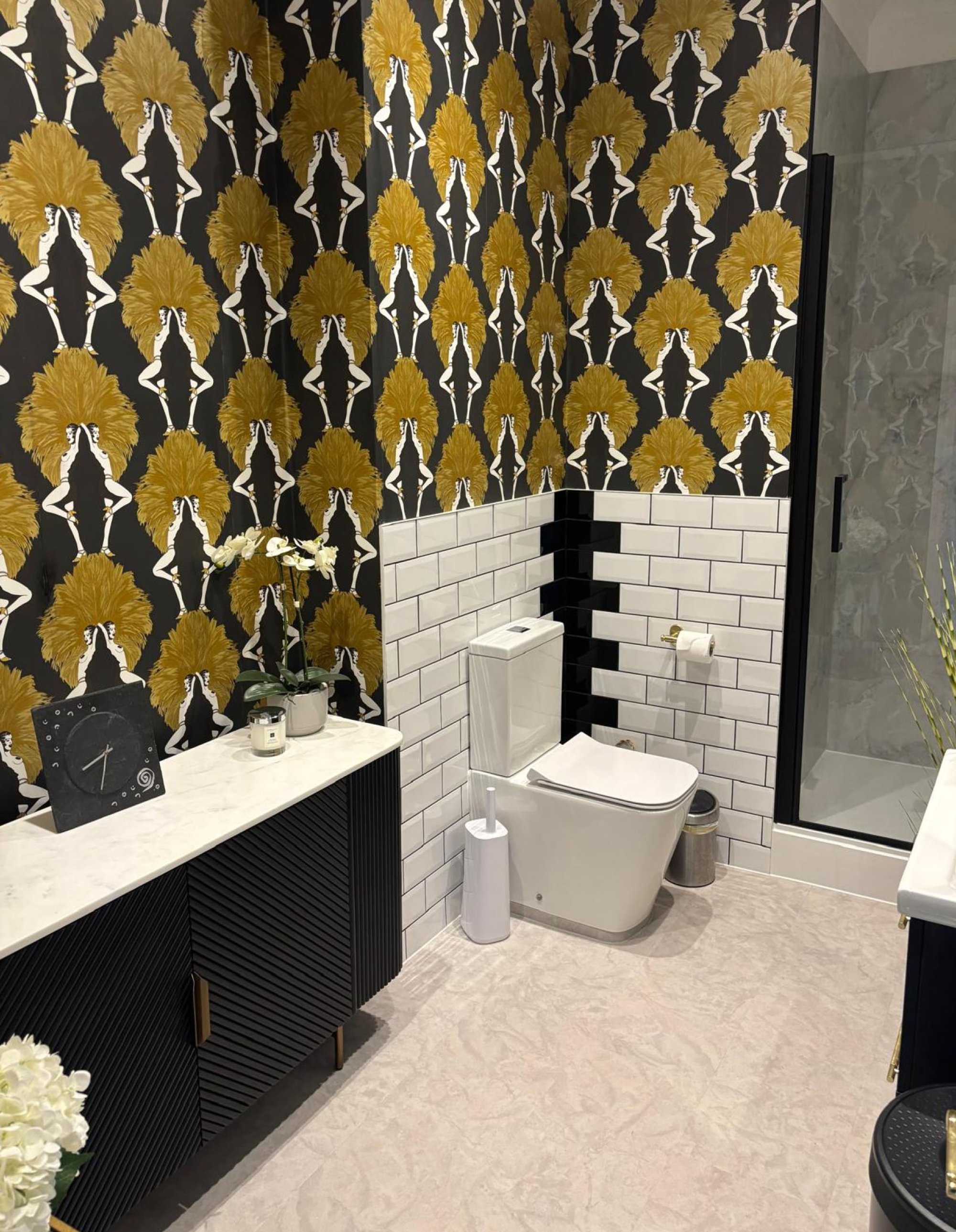 Black-and-gold bathroom with patterned wallpaper and toilet