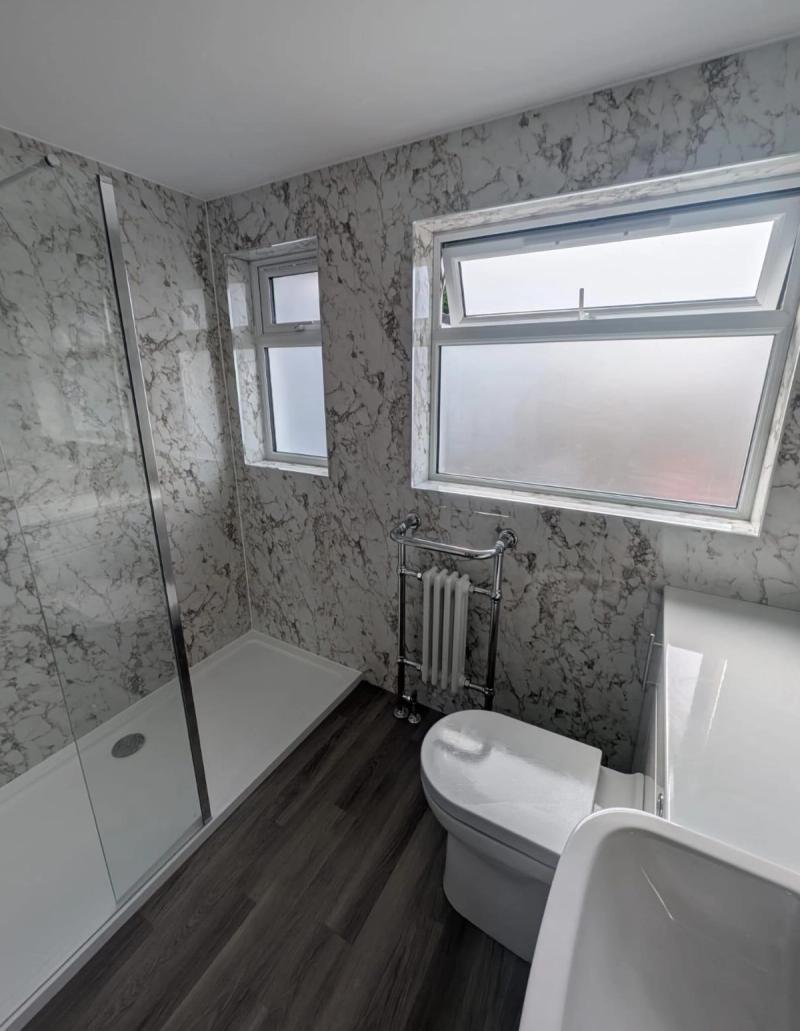 Marble-pattern bathroom with shower and windows