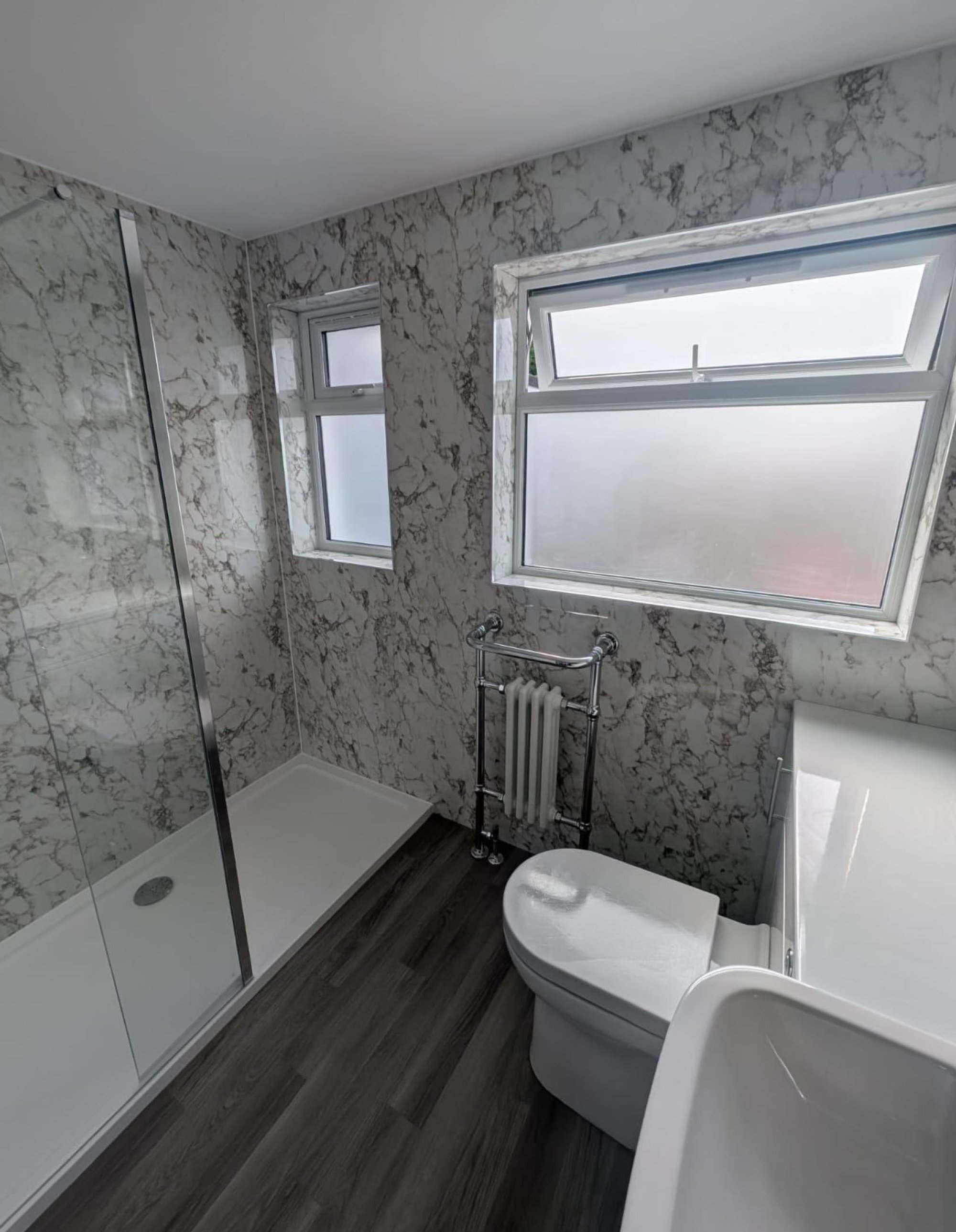 Marble-pattern bathroom with shower and windows