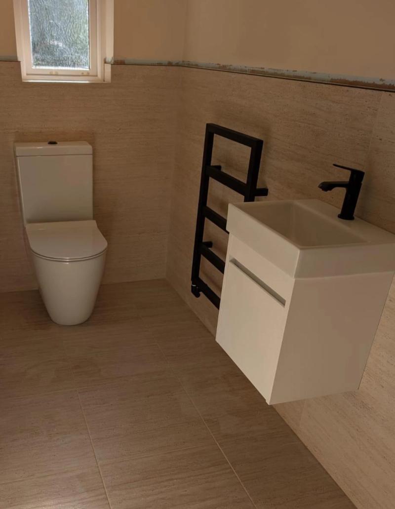 Beige tiled cloakroom with wall-mounted vanity