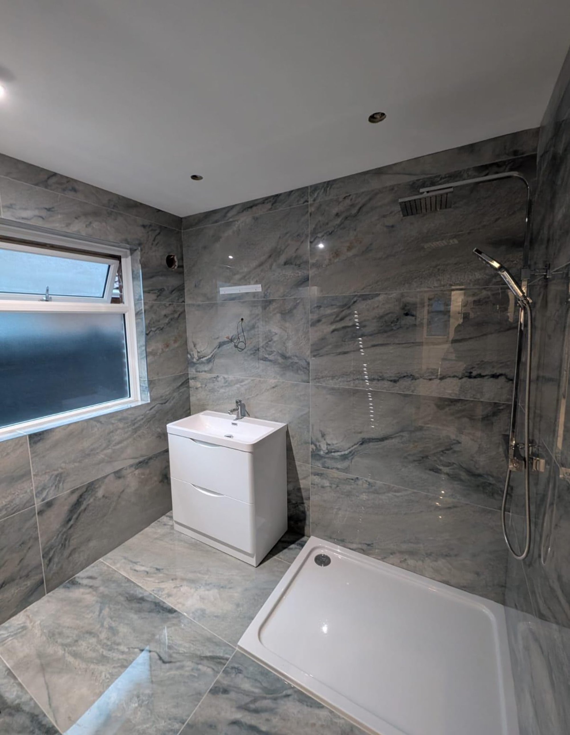 Grey marble-tiled shower and vanity
