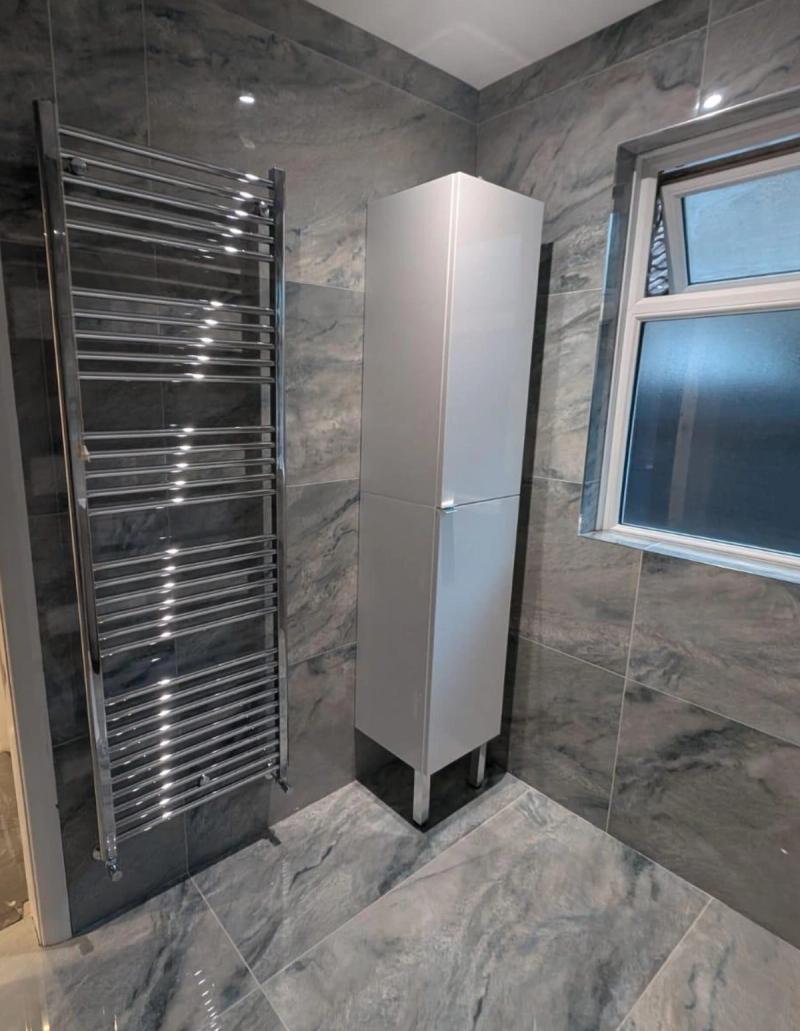 Grey marble bathroom with towel rail and cabinet