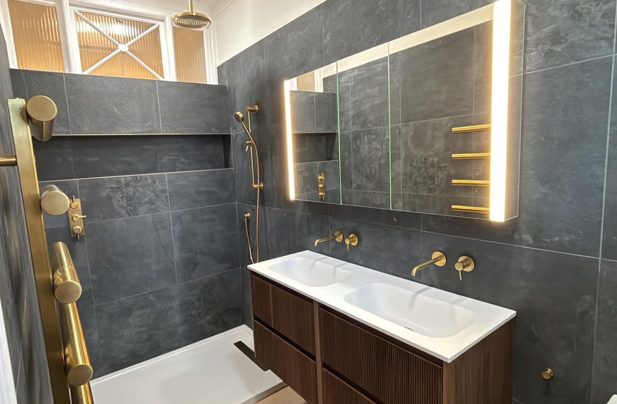 Dark grey bathroom with gold fixtures and double vanity