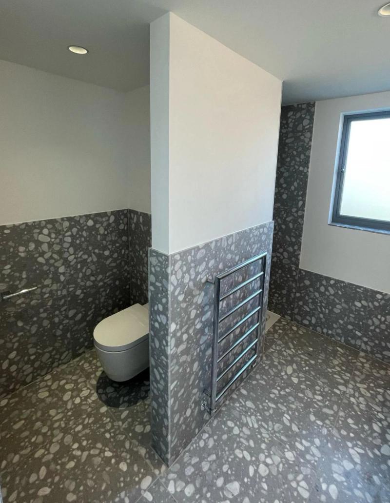 Terrazzo-tiled bathroom with dividing wall
