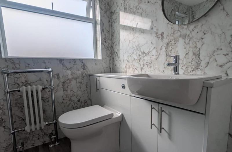 Marble-pattern bathroom with toilet and vanity