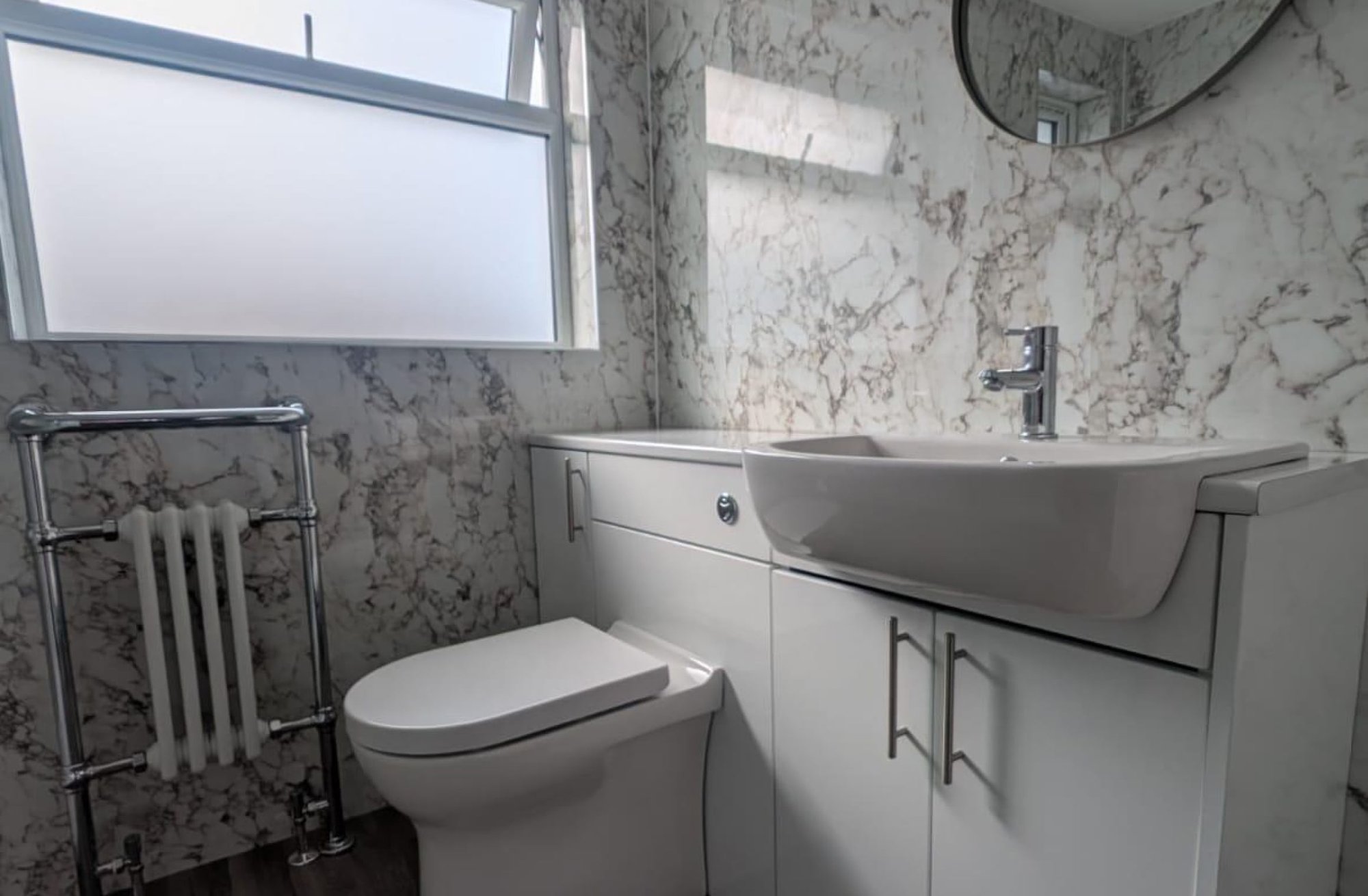 Marble-pattern bathroom with toilet and vanity