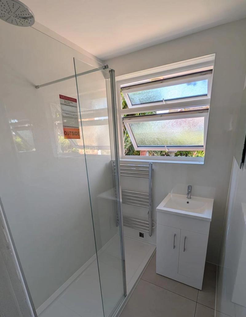 Narrow bathroom with walk-in shower and vanity