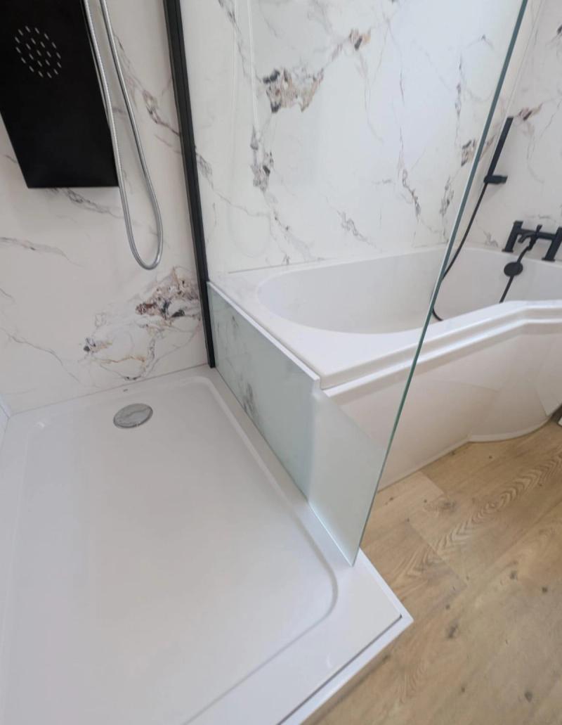Shower tray beside corner bathtub