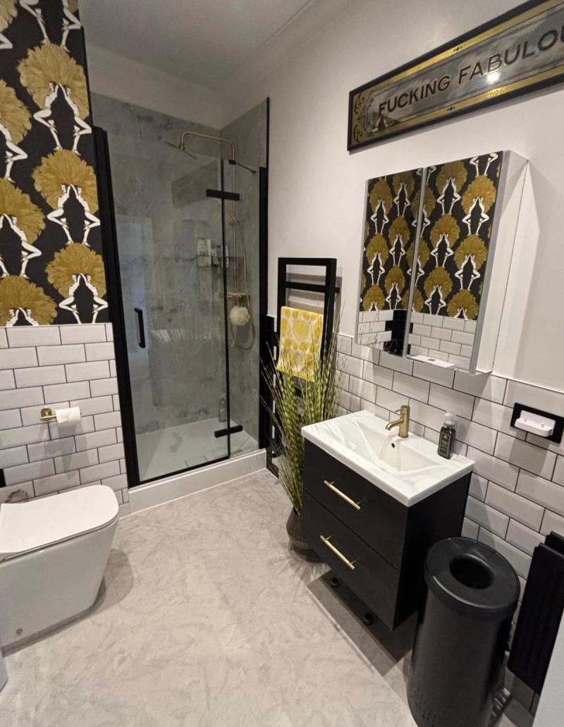 Black-and-gold bathroom with patterned wallpaper