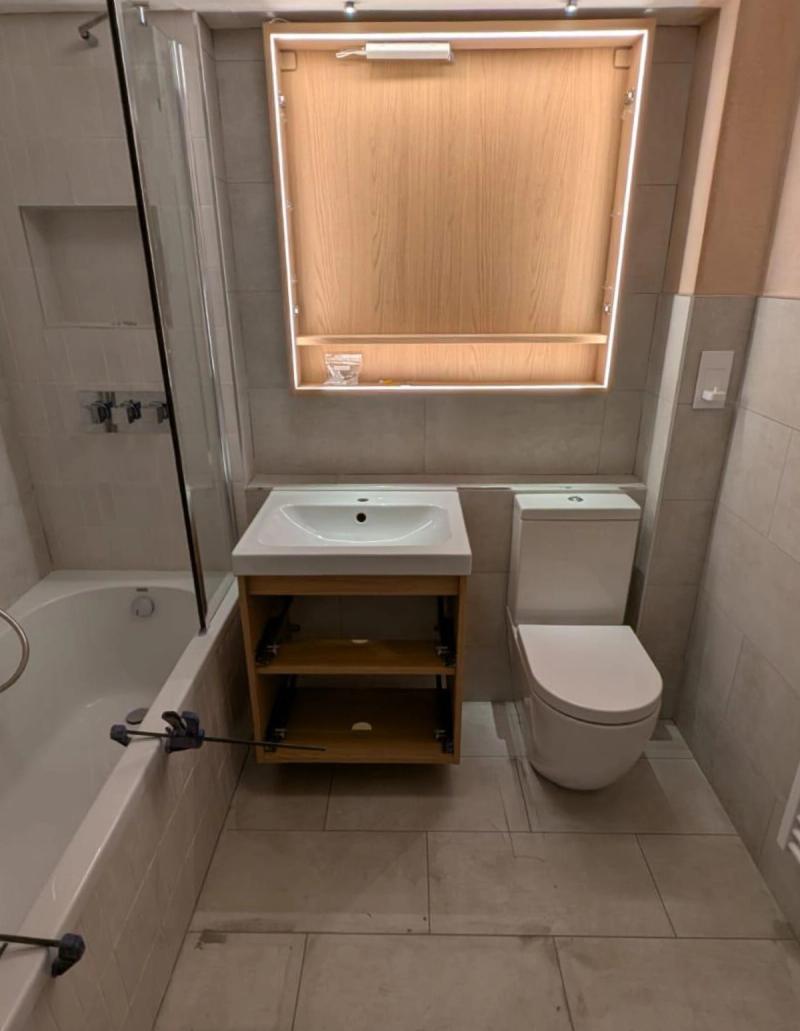 Partially renovated bathroom with tub and vanity