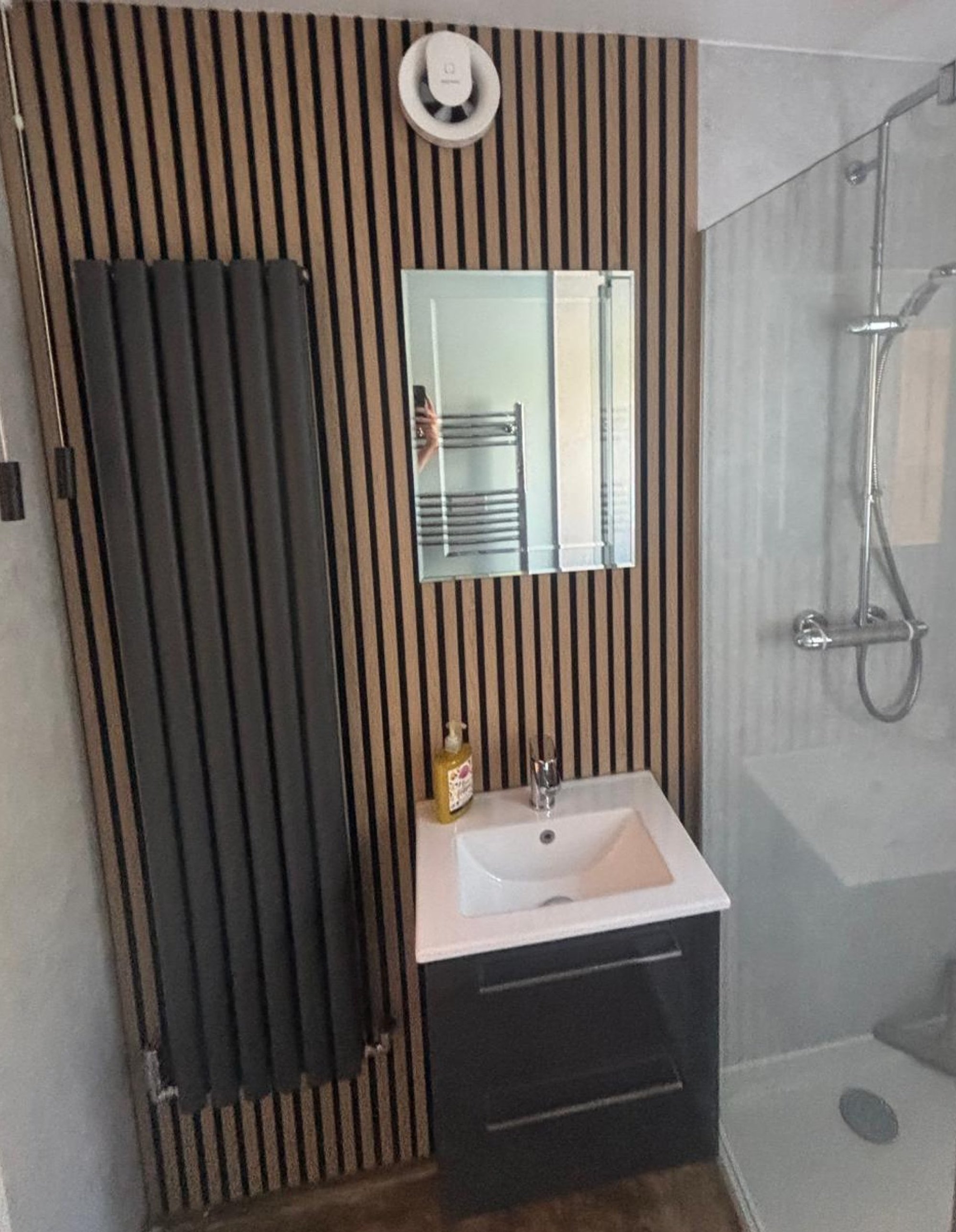 Compact bathroom with wood slat wall and shower