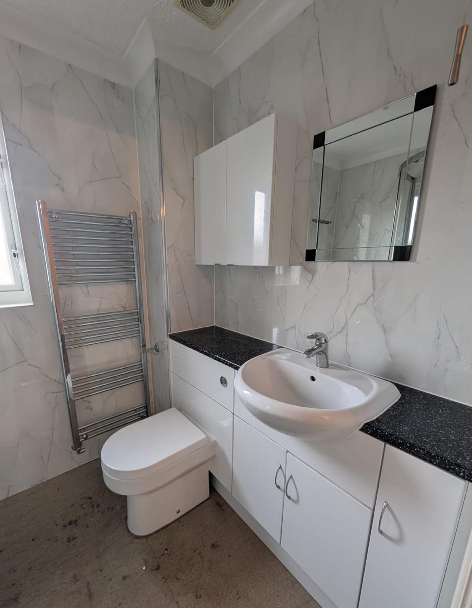 Marble-tiled bathroom with vanity and toilet