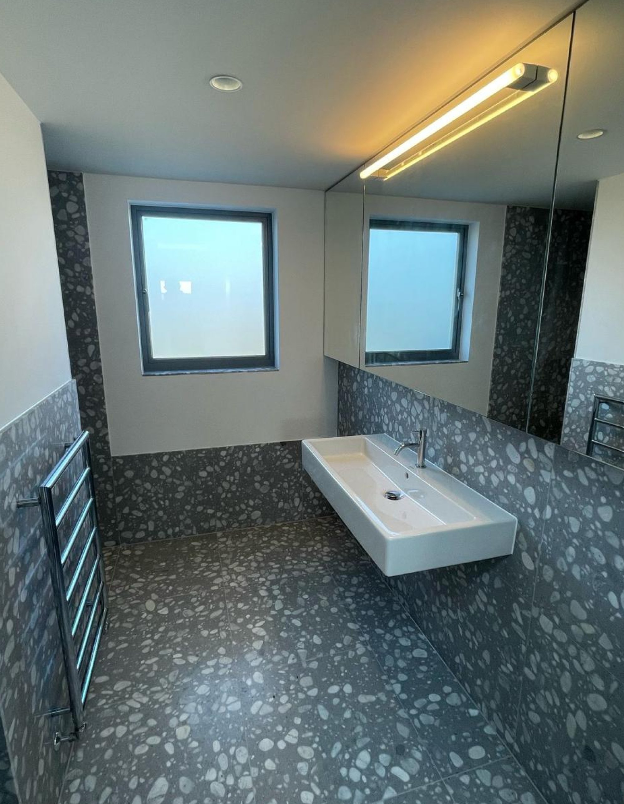 Terrazzo bathroom with floating sink and mirror