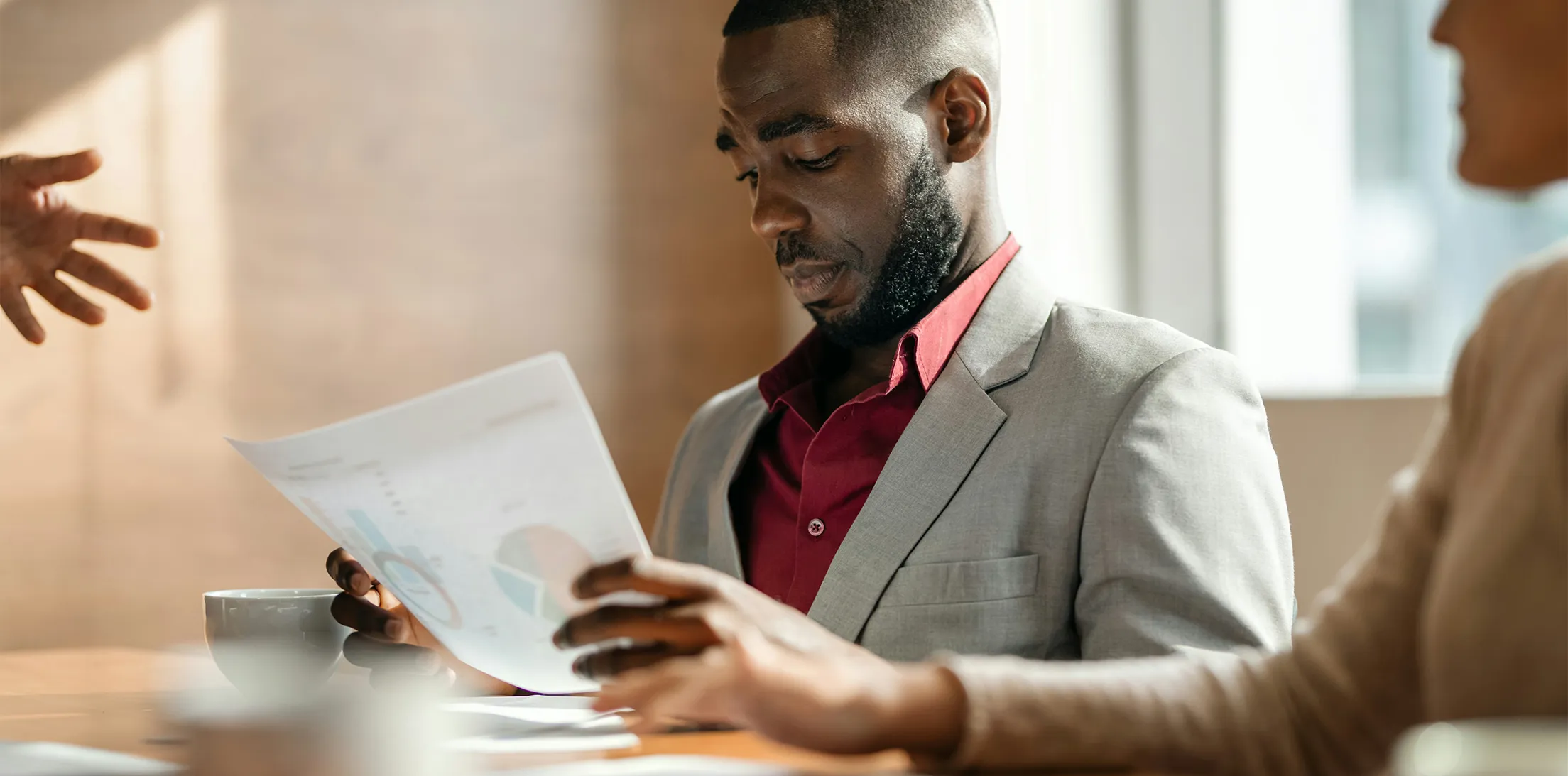 A professional reviewing financial documents during a meeting.