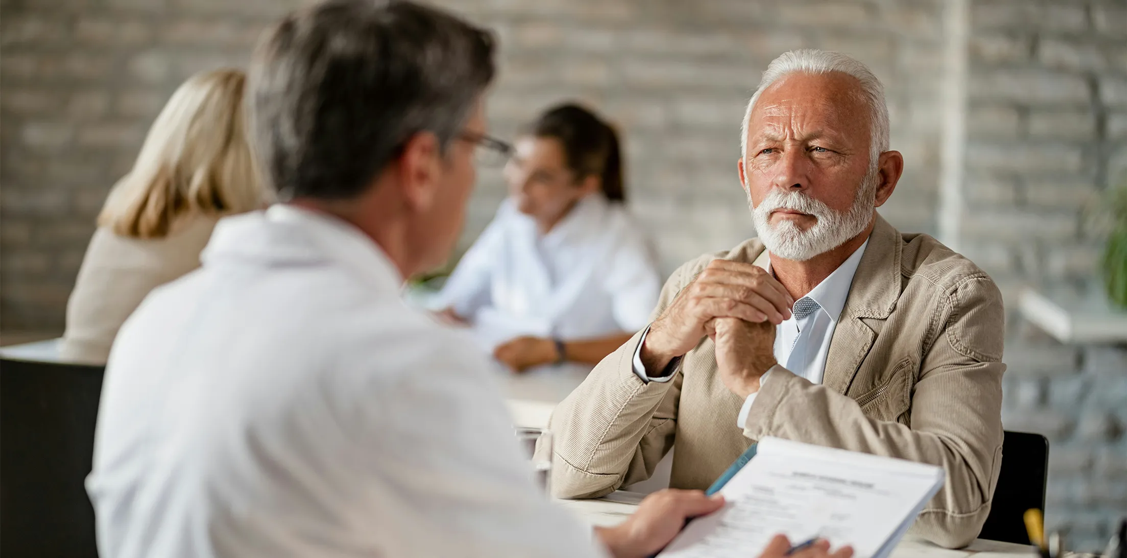 An older man discussing financial plans with an advisor.