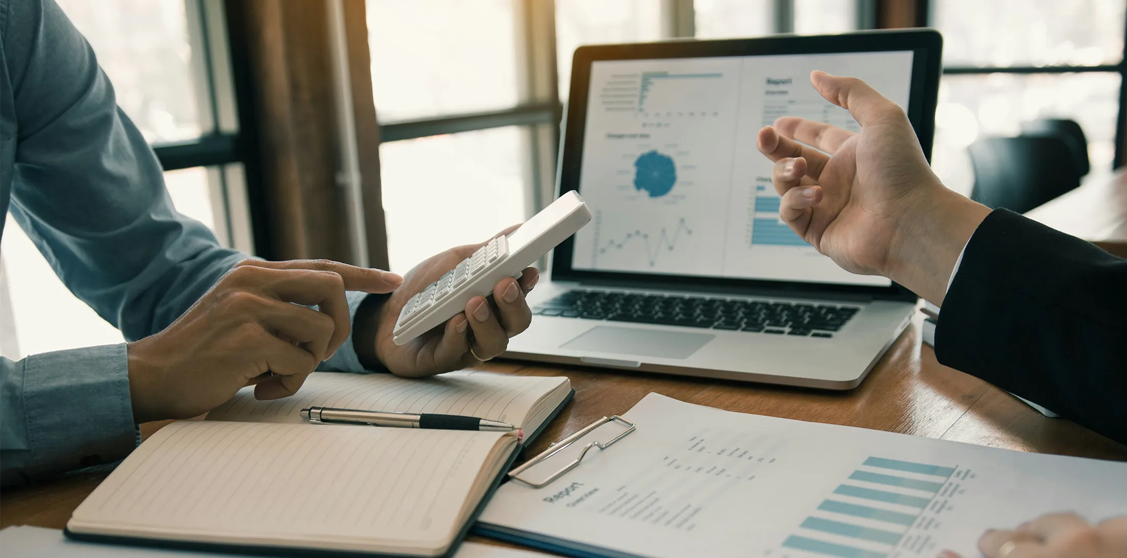 Two professionals reviewing financial reports and calculations.