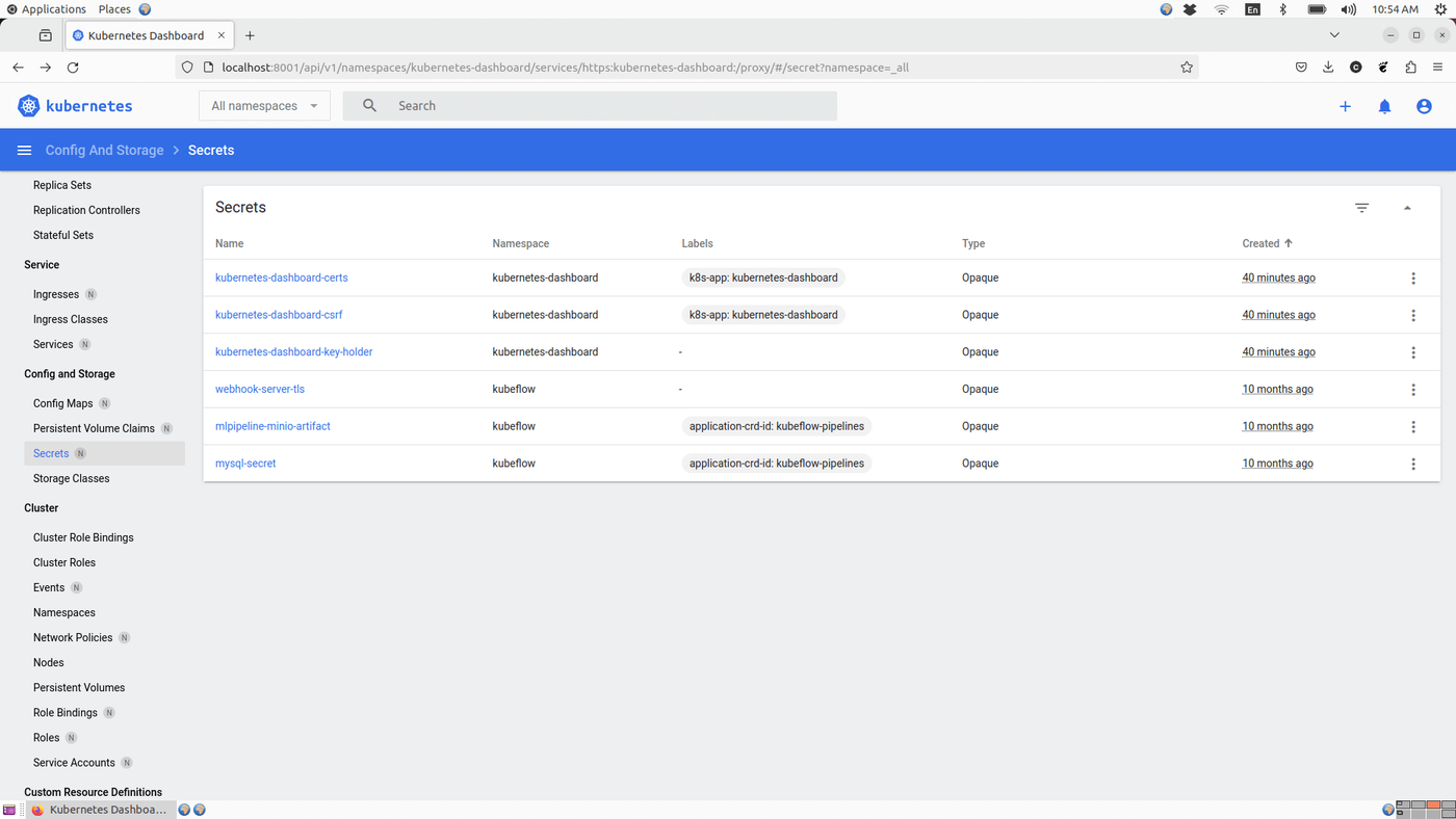 Kubernetes Dashboard showing a list of secrets in different namespaces, including kubernetes-dashboard and kubeflow, with labels, types, and creation timestamps.