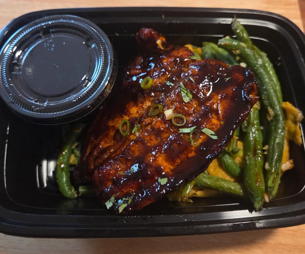 Authentic Brown Stew Salmon meal prep by Saucy Kim K. Features tender salmon caramelized in traditional Caribbean spices, served with fresh garlic green beans. Prepared by Johnson & Wales trained Chef Kimberly Kee for luxury clients in Providence RI, Boston MA, and Greenwich CT.