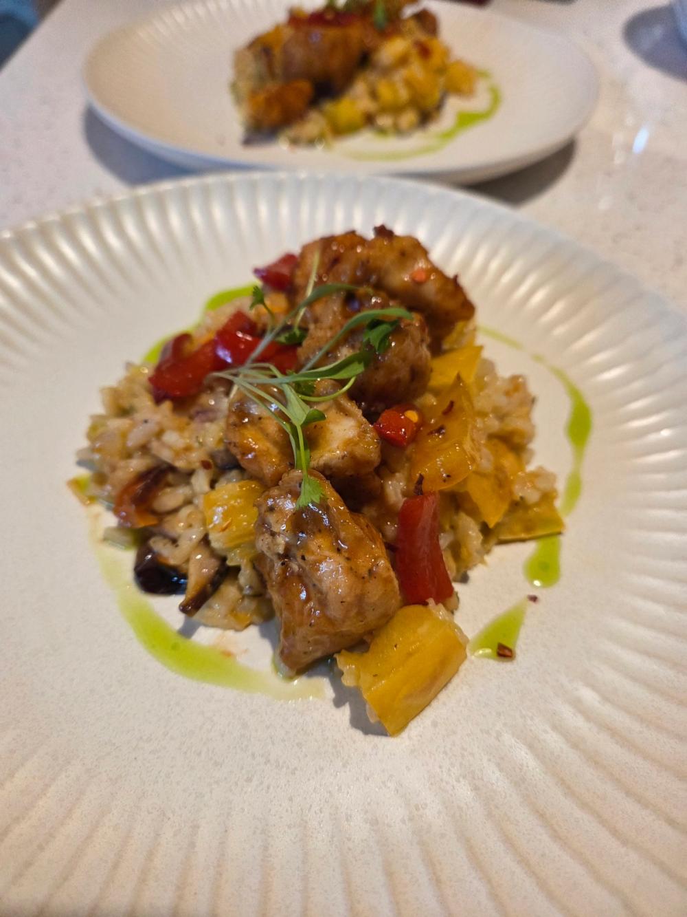 Modern Caribbean fusion Sweet and Sour Chicken by Chef Kimberly Kee of Saucy Kim K, presented on a creamy vegetable risotto with handcrafted scallion oil and red pepper flakes. Luxury private dining and boutique catering services serving Providence RI, Boston MA, and Greenwich CT.