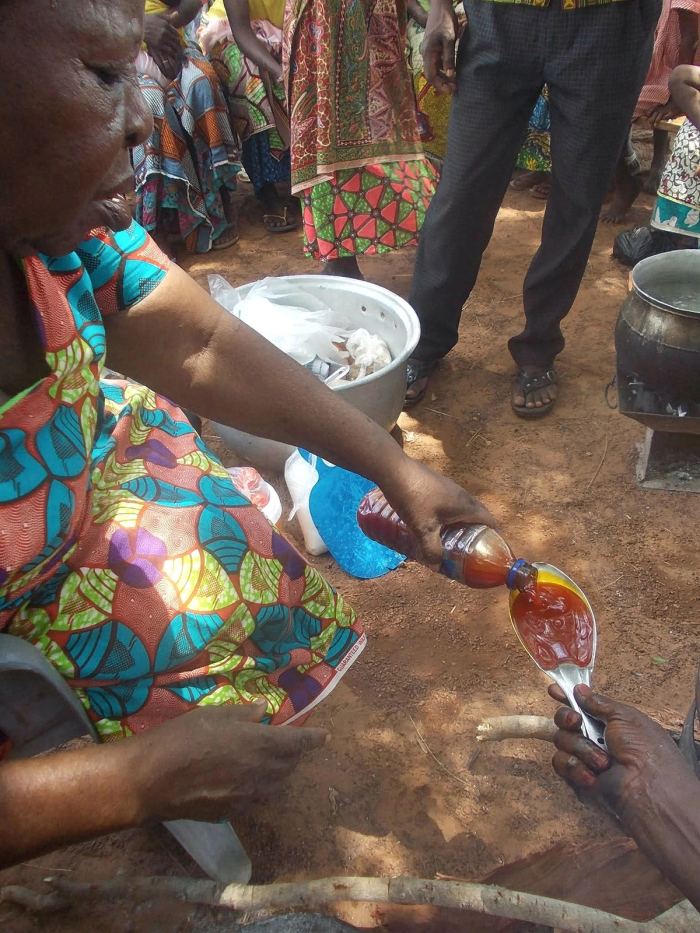 A drink being poured for a child at a community meal