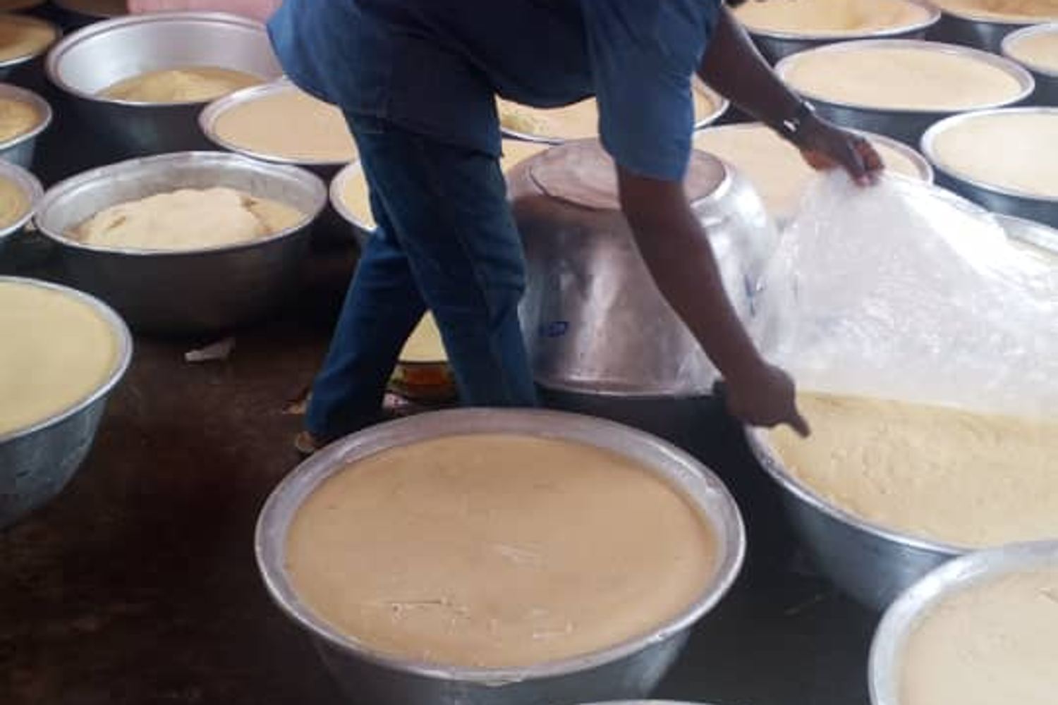 Batter being prepared in large basins for a community meal