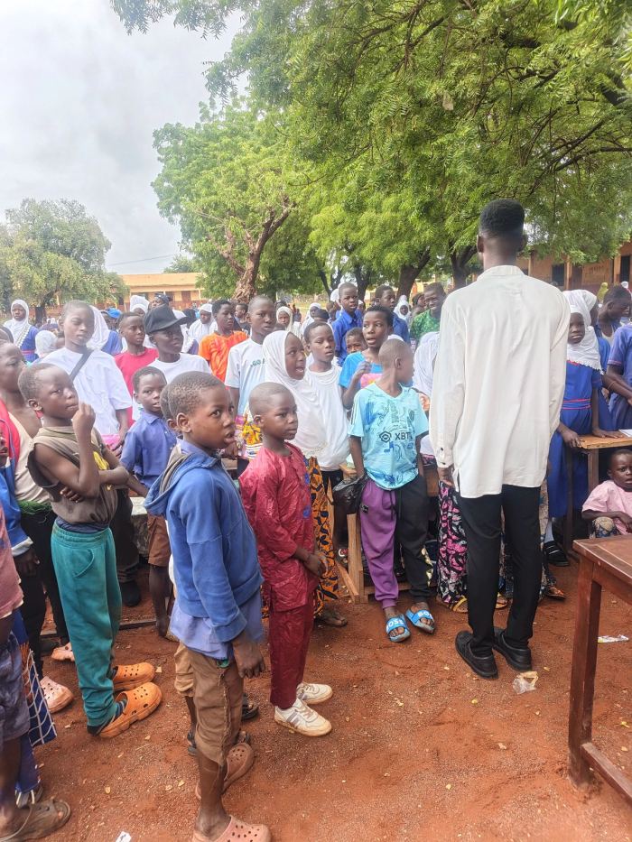 Pupils lining up in the schoolyard to receive supplies