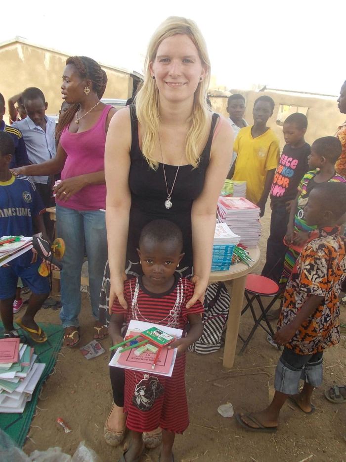 A child receiving exercise books at a distribution
