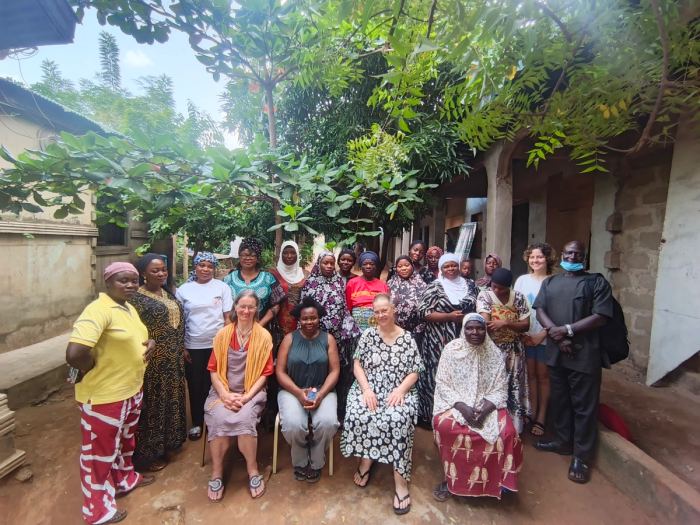 Women of the foundation with visiting partners outside a community building