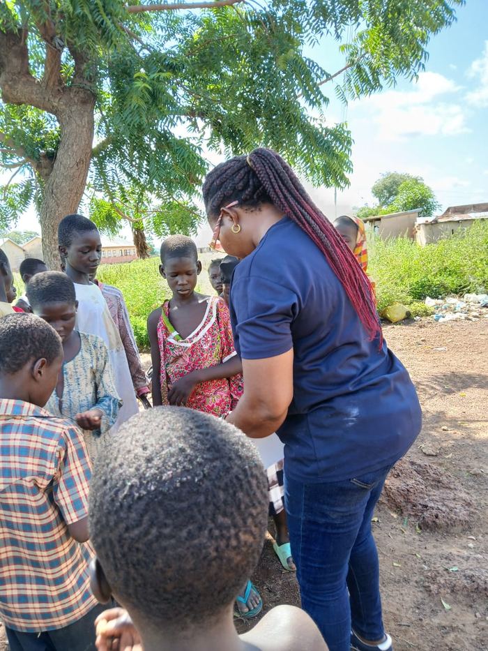 Children waiting with a volunteer in a village