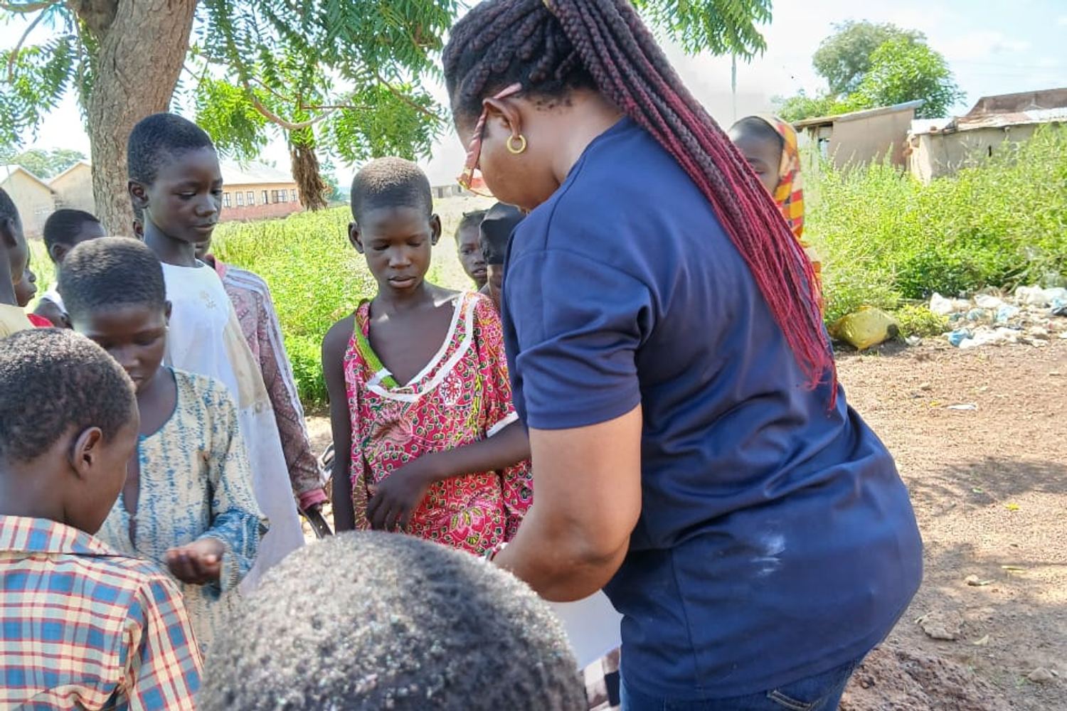 Children waiting with a volunteer in a village