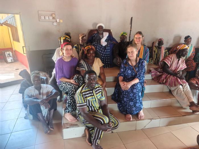 Community members and visitors gathered on the steps of a meeting hall