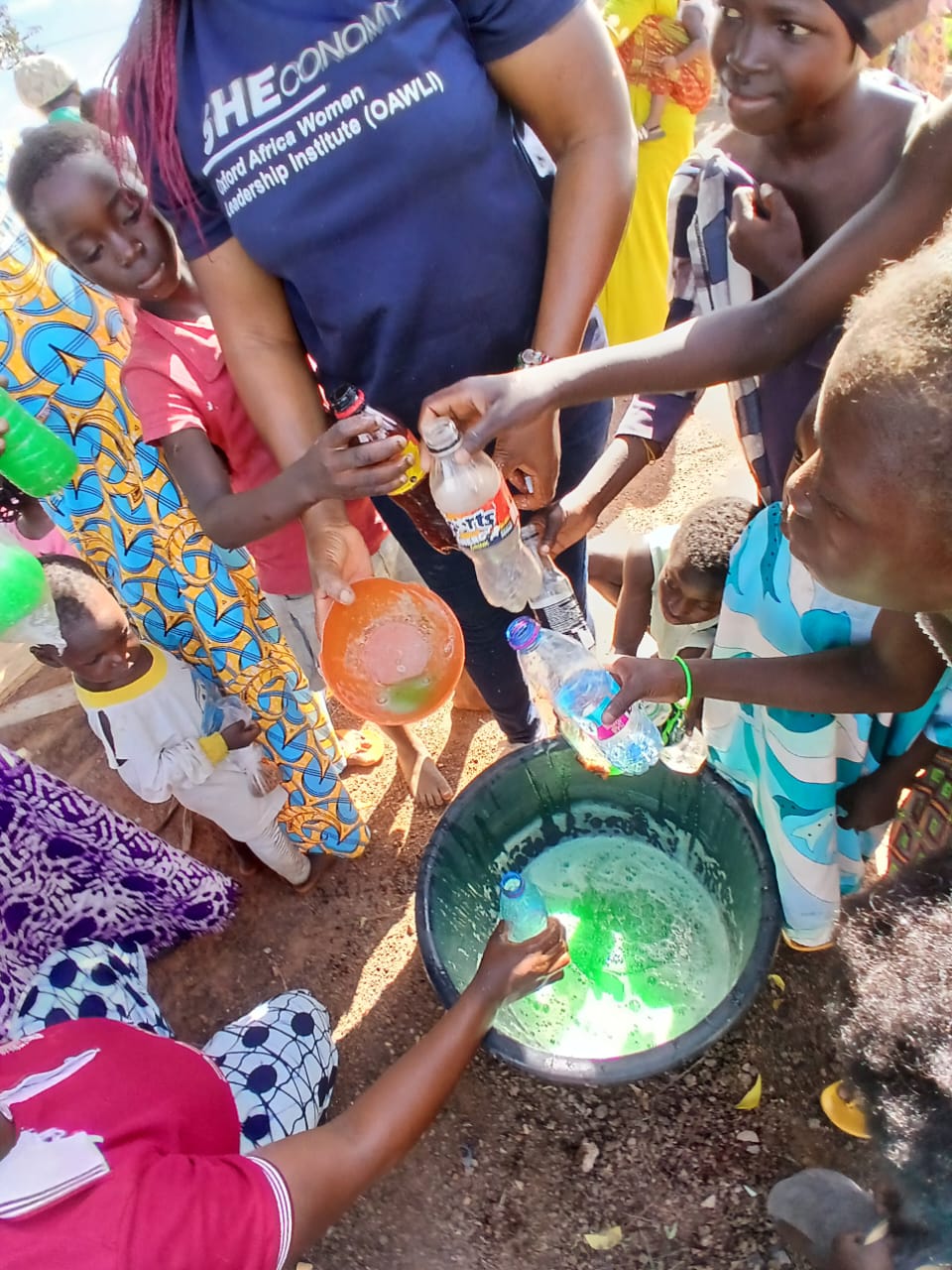 A woman pouring liquid soap into a bowl at a training
