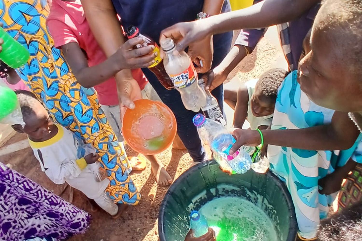 A woman pouring liquid soap into a bowl at a training