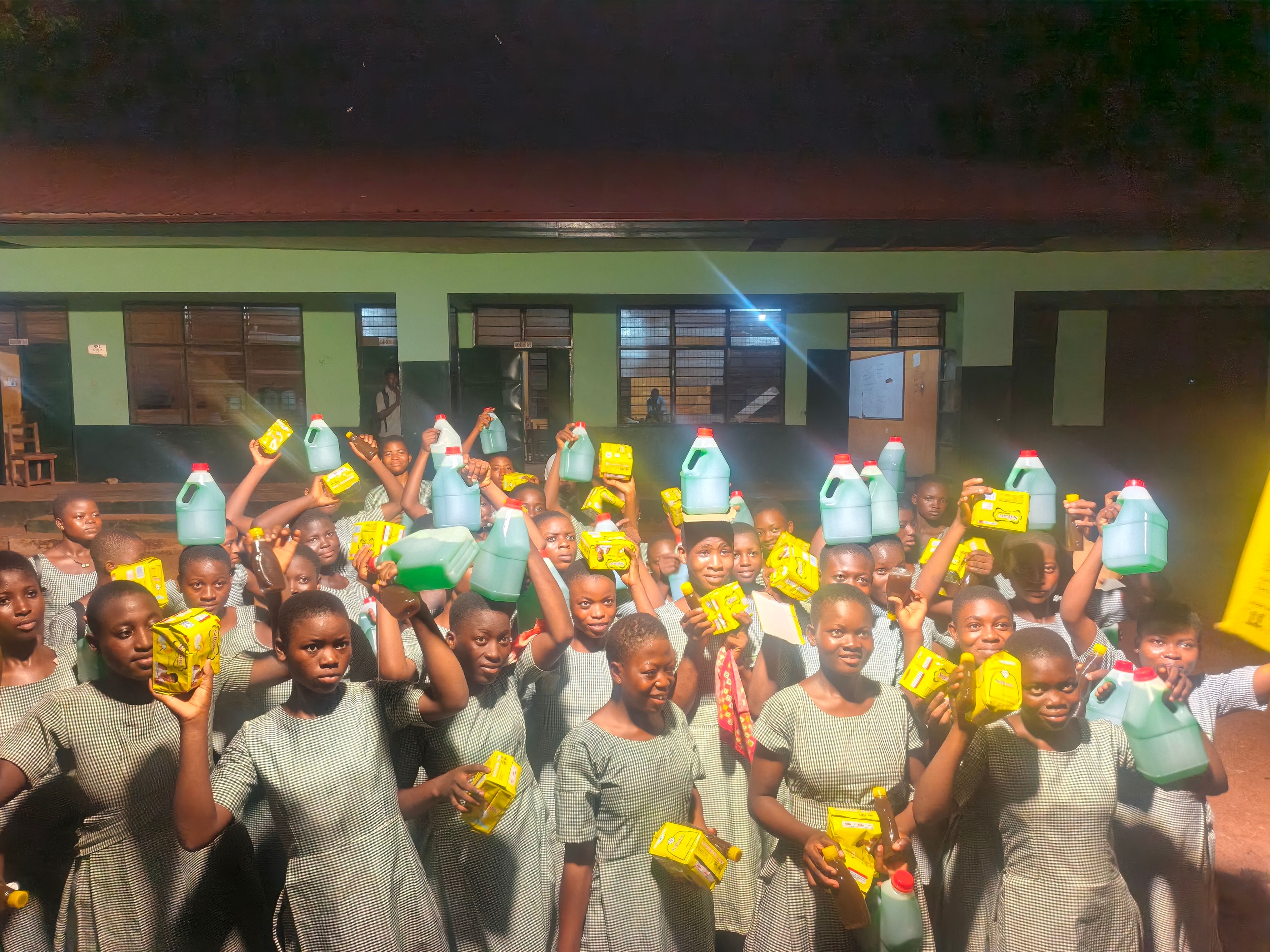 A schoolyard full of children with the supplies they have just received