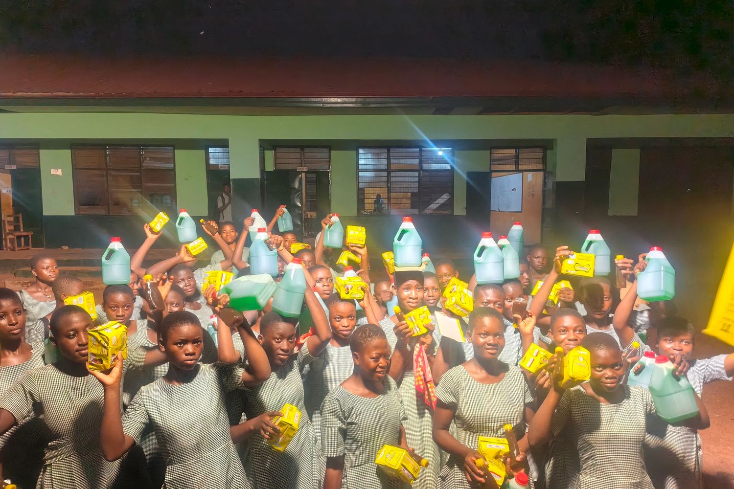 A schoolyard full of children with the supplies they have just received