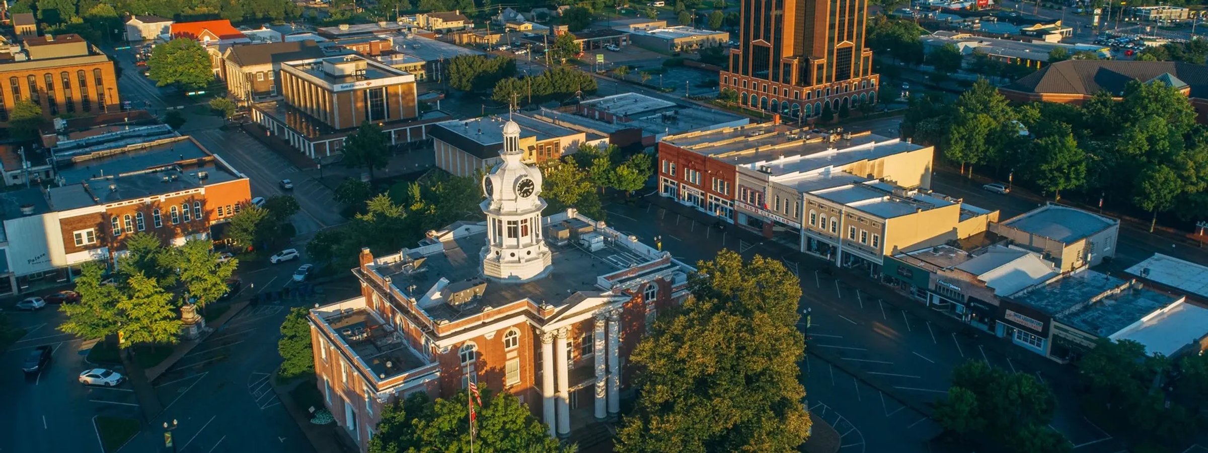 Aerial view of downtown Murfreesboro at golden hour, the white clock-tower courthouse rising from the historic square.