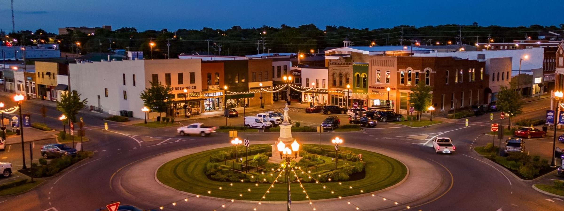 Aerial view of Lebanon's historic square at dusk, string lights around the monument in the center roundabout.