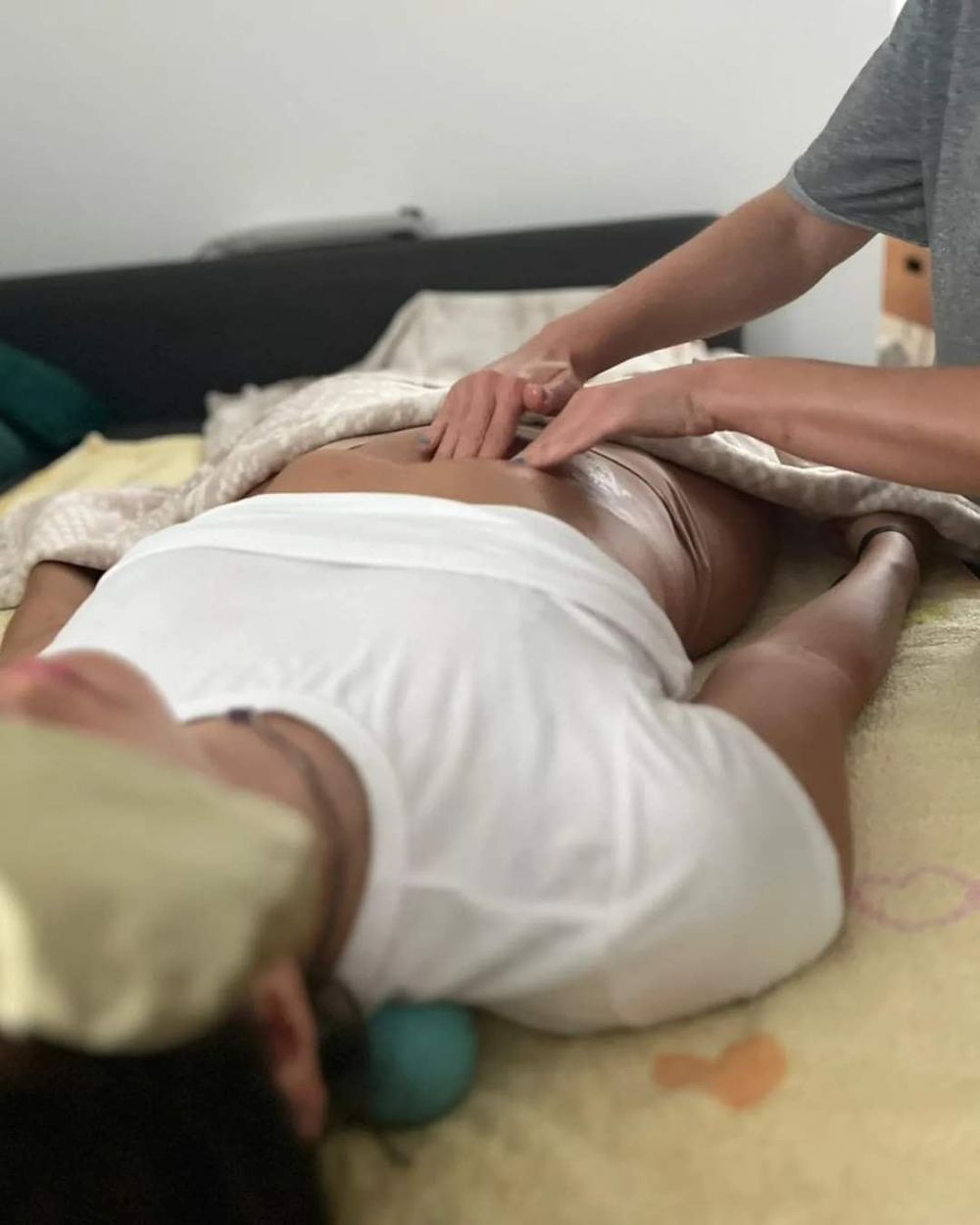 As mãos da Anica a trabalhar as costas de uma cliente