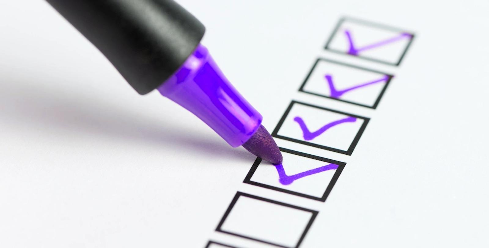 Purple marker checking off boxes on a checklist, representing Dancing Pels growth marketing strategy and execution.