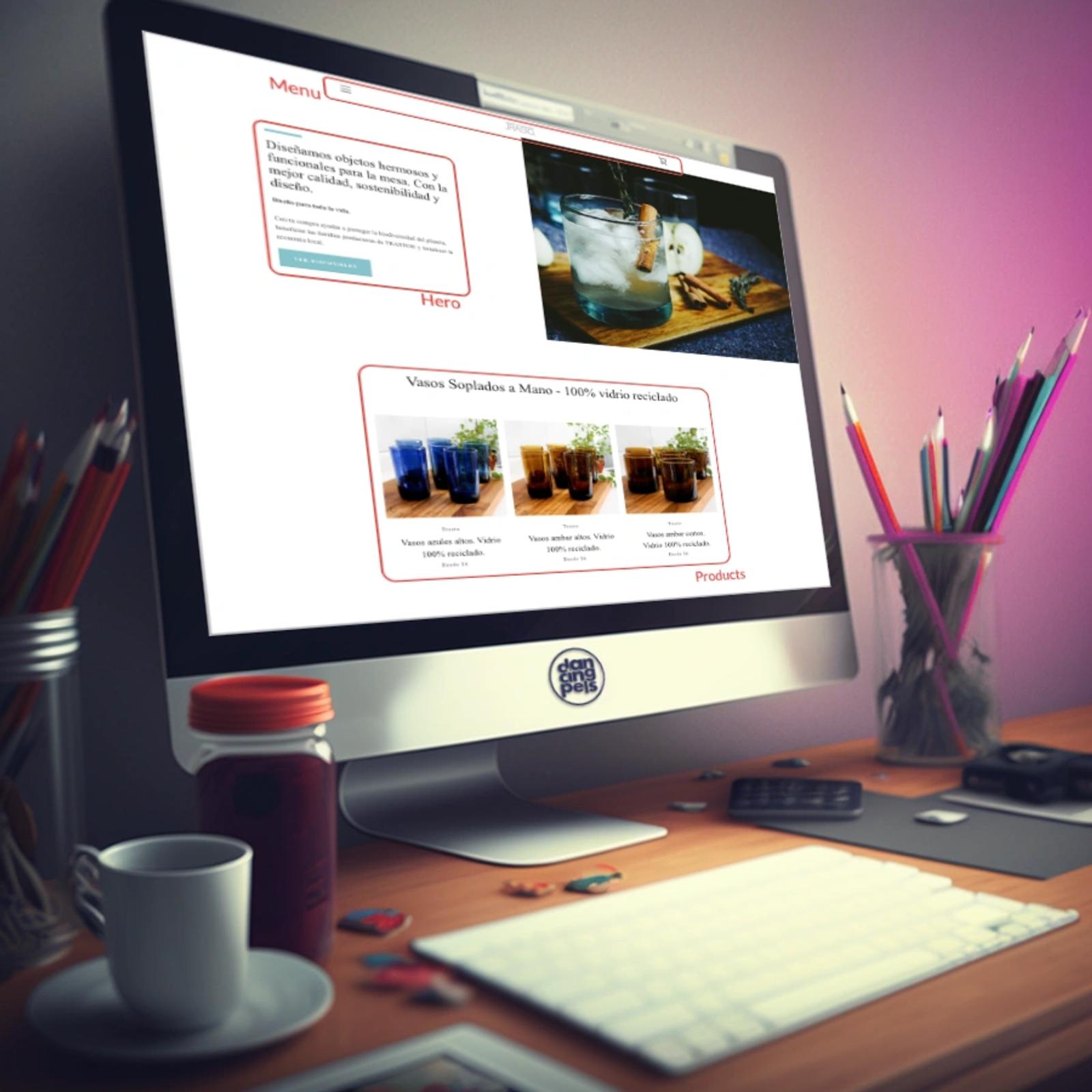 Desktop monitor displaying a custom website design with product photography and menu sections for a beverage brand, surrounded by design workspace elements.