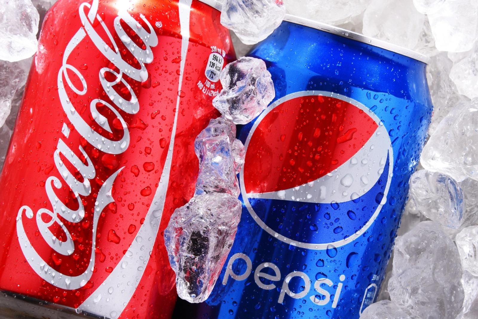 Coca-Cola and Pepsi cans surrounded by ice cubes, representing competitive positioning and market differentiation strategy.