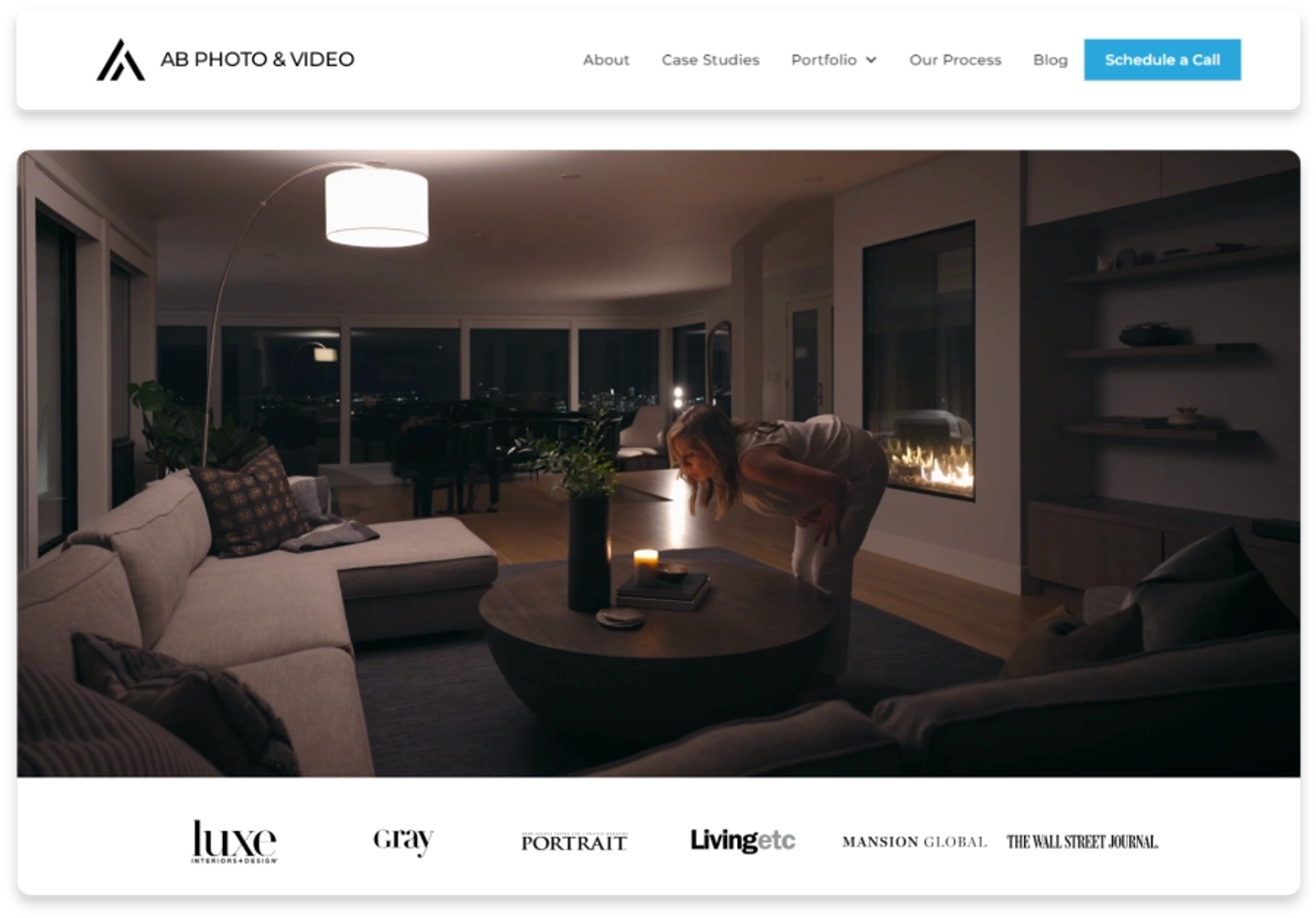 A modern penthouse living room with floor-to-ceiling windows, contemporary furnishings, and ambient lighting—the type of high-end interior photography Dancing Pels creates for luxury lifestyle brands.