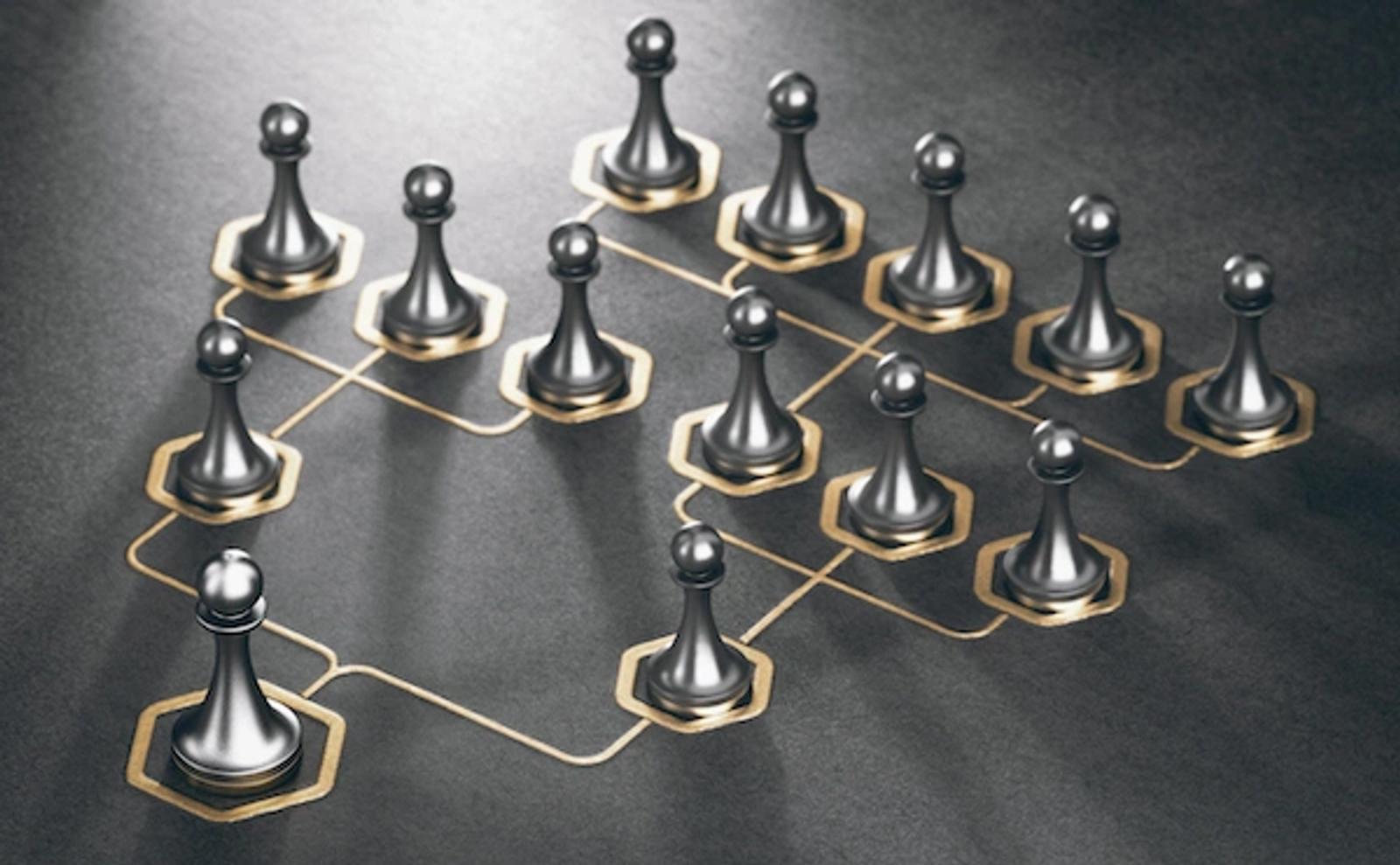 Interconnected silver and gold chess pieces arranged in a hierarchical network pattern, representing organizational structure and strategic planning for business growth.